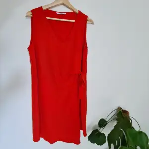 Klarröd klänning med knyt i sidan. Bra kvalitet och har ett superfint fall!