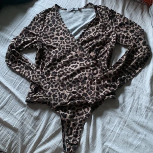 Leopard body - En leopard body med långa ärmar. Den har ett litet hål som man ser på 2 bilden men de är inget som syns eller påverkar när man har på sig den