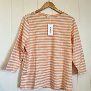 Oanvänd Marimekko tröja i perfekt skick med etiketten kvar. Vit/laxrosa randig tröja med trekvarts ärm, storlek XXL.