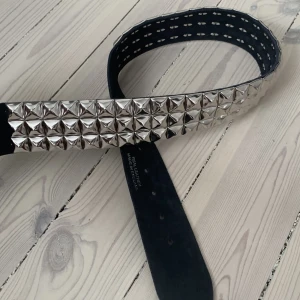 Svart Nit bälte - Säljer mitt Svarta Nit bälte som är i nyskick och äkta läder! Den är ungefär 100cm Lång och passar de flesta för har många hål! Skriv om du har några funderingar😊