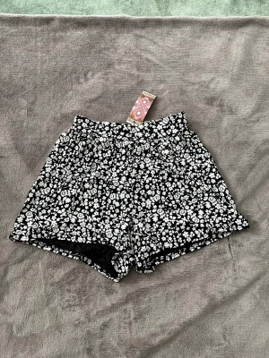 Shorts  - Aldrig använda. Svarta shorts med blommor från boohoo, storlek 38🤍 Köpare står för fraktkostnaden!
