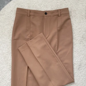 Beigea kostymbyxor från Zara! - Supersnygga och bekväma tygbyxor från Zara med pressveck framtill! Byxorna är i gott skick då de endast är använda ett fåtal gånger💘
