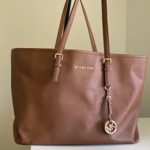 Michael Kors väska - En fin och rymlig märkes väska från Michael Kors. En ”defekt” på ena sidan men det blir så på alla väskor som varit älskade och använda❤️ Så därför nedsatt pris 😍Nypris: ca 2000 kr Storlek: bredd 35 cm, höjd 28 cm, djup 15cm🥰 frakt ingår💖💖