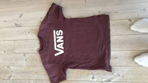 Vans vin röd - En Vans tröja som är o ganska bra skick bara tre små hål vid magen som man knappast ser annars bra skick och storleken är 10-12 år M custom fit med ett pris på 65 kr