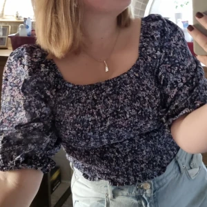 Topp - Blommig blus med puffärmar. Passar många storlekar med resåren.