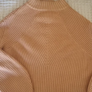 Fin kort stickad tröja.  - En kortare modell på stickad gammelrosa tröja.  