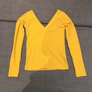 Långärmad topp - Gul tröja från Bikbok med V ringning. Använd några gånger men i väldigt bra skick. Storlek S.