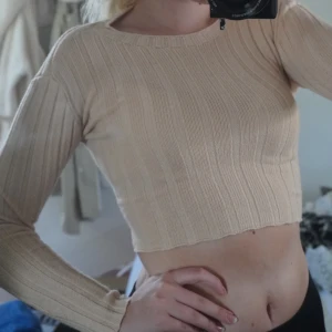 Topp med knytning - En stickad, croppad topp med knytning baktill i från madlady🤩Storlek XS.