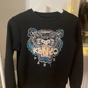 Kenzo Sweatshirt Svart - En perfekt tröja inför Hösten som är i ett otroligt bra skick, köpt för ett år sen men inte använd mer en 15 gånger, jag säljer den för att jag har växt ut den, Tröjan håller ett toppen skick och är i otroligt bra kvalite. Skick 8,5/10