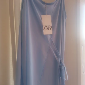Zara Klänning 💙 - 🥴En superfin klänning från  zara i mycket mjukt material i babyblå färg 💙Perfekt som sommarklänning. Helt ny med prislapp kvar. Knyts i midjan så skulle säga att den kan passa allt från S till L ✨💙