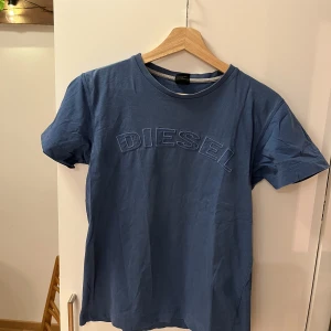 Blå DIESEL tröja - Säljer en blå DIESEL t-shirt i storlek S. Den har lite småhål där vissa är lagade med inget man tänker så mycket på. Sitter ganska tajt på mig som är s/m. Väldigt fin blå färg. 