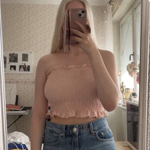 Ljusrosa bandeautopp - En supersöt ljusrosa räfflad bandeau-topp med volang upptill och nedtill från Nelly i strl S!💓