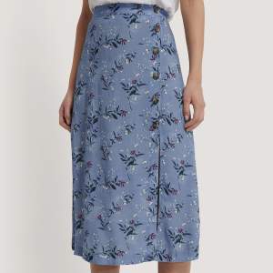En oanvänd lång blå kjol med blommor och knappar från Vero Moda i strl 36 med lappen kvar! 💓