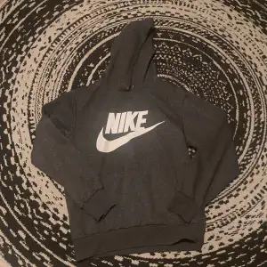 En Nike hoodie i färgen grå. Står inte men skulle säga att det är storlek M. 