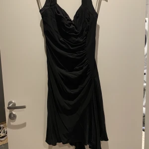 Svart klänning - Svart kort klänning med halterneck från Karen Miller. 