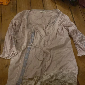 Blus med brodering  - Väldigt fin blus i gammelrosa med inslag av lila och blått i form av brodering. 