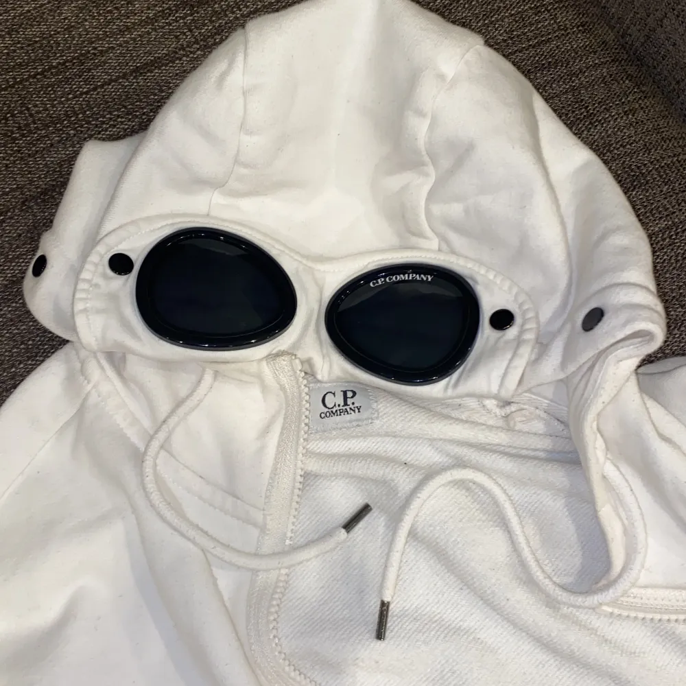 Tjena säljer min vita cp company zip hoodie som jag köpte på NK i Göteborg. Skicket är typ 9/10, utsidan är super fin men lite missfärgning från smink på insidan av en tjej… annars inga problem över huvudtaget. Kan skicka fler bilder i DM. Nypris 2499kr. Hoodies.
