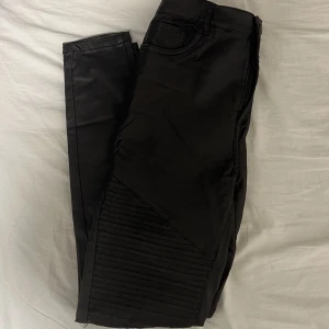 ”Fejk”-skinn byxor - Byxor i ”fejk”-skinn. Stretchigt material. ”Lappar” på knäna. Storlek M. Från vero moda