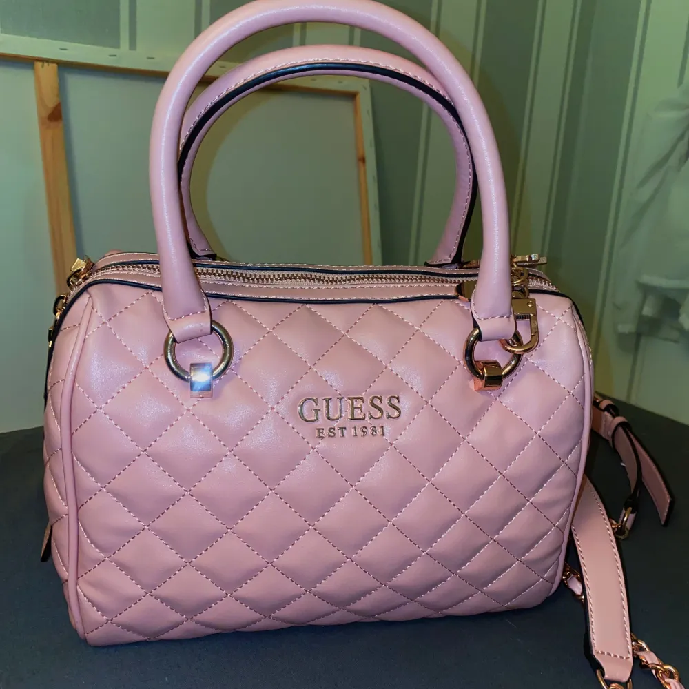 Superfin rosa väska från Guess, den är helt ny, endast använt den en gång, sedan dess har den bara legat i garderoben. c.30 cm i bredden, kan skicka fler bilder ifall det önskas !! . Väskor.