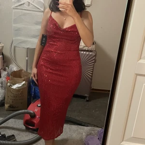 Röd paljettklänning  - Köpt på NAKD, använd en gång. Nypris 699kr. Yttertyg: 90% Polyester, 10% Elastan. Foder: 100% Polyester. Dekoration: 100% Polyeten.