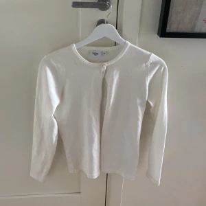 Vit kofta - Hej! Nu säljer jag denna super snygga koftan för jag inte vet hur jag ska styla den! Den är i jätte bra skick och ändrat använd 1-2 ggr. Köpte den kannan sommarlovet och den har inga defekter eller smutsig. Köpt på vila! Kontakta för fler bilder och info!