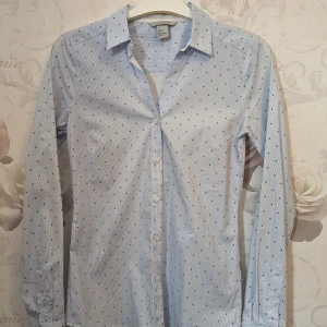 Stretchig och kroppsnära skjorta - Denna skjortan är i ett mjukt och stretchigt tyg med v-rinhad hals, aldrig använd.