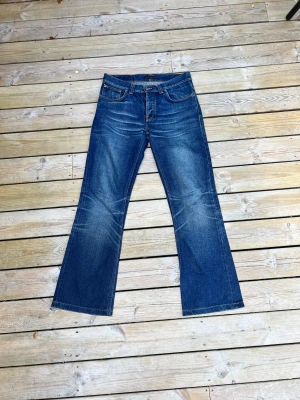 Lågmidjade Bootcut jeans - Lågmidjade bootcut jeans i mörkblå tvätt från Nudie Jeans CO, Nypris: 1600kr  kommer i fint skick, långa i benen