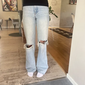 Zara jeans - Säljer nu dessa högmidjade bootcut jeans från zara med hål i båda knäna. De har används mycket så de är lite slitna längst ner. 