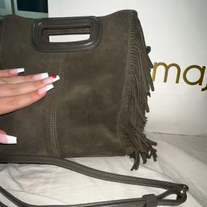 maje väska  - Hej!, säljer denna maje väska i mocka material och skit fin skogsgrön färg! det är guld detaljer på och den är i nyskick! 💚 UUURSNYGG mörk grön färg, väldigt het färg från maje. PERFEKT FÄRG BÅDE HÖRST, VÅR, VINTER, SOMMAR!  NYPRIS: 2799kr.