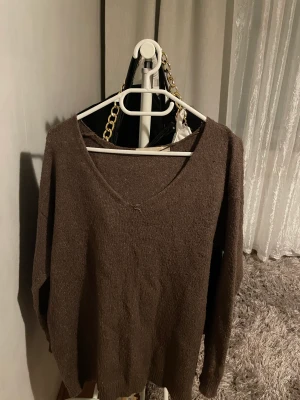 Brun stickad tröja - Säljer denna snygga tröja då den inte kommer till användning längre. Den är använd och i ganska bra skick. Det ända dåliga är att sömmen gått upp lite på framsidan, men däremot inget som syns eller stör än. (Skriv för fler bilder)