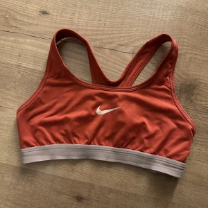 Nike sport topp  - I använt skick, men kvaliten på dessa toppar är verkligen hållbara. Färgen är typ en ljusare röd. Storlek S 