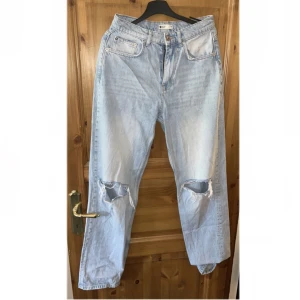 Jeans  - Ett par raka ljusblå jeans med hål vid knäna som ej kommer till användning, inga skavanker 