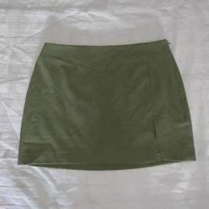 Grön kort minikjol med dragkedja på ena sidan 🤍 midjemåttet rakt över är ungefär 34cm