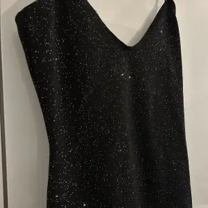 Kort glittrig klänning med skrunch där bak, använd 1 gång 