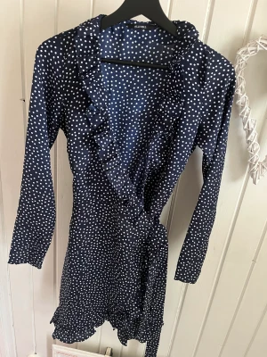 Klänning  - Marinblå omlott klänning. Klänningen är mer marinblå i verkligheten och inte så mörk som på bild 