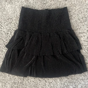 Mini kjol glittrig - En jättefin neo noir kjol använd 1 gång❤️ det är volang o den är svart glittrig 