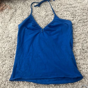 Blå topp - En fin blå ganska gammal topp den säljs inte längre❤️ den låg i ryggen o har bara ett band runt nacken man kan knyta o justera❤️