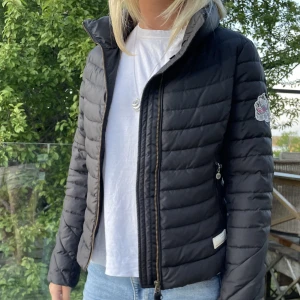 Dunjacka Odd Molly - Mörkbrun/grå dunjacka från Odd Molly. Jättefint skick! Storlek 0 vilekt motsvarar XS. Jag själv är en storlek S/M så sitter tajt på mig!