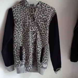 Svart/leopard mönstrad hoodie - Svart/leopardmönstrad hoodie. Mysig och tjock med knappar. 