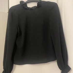 Svart blus  - Fin svart blus med knytning där bak!