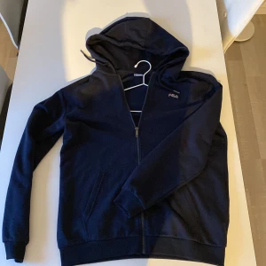 Fila Hoodie Zipper, Navy Blue  - Fila Hoodie, med dragkedja. Storlek M men sitter som L. Knappt använd, färgen är som sagt blå. Dålig belysning på bilderna. 
