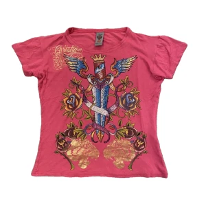 Ed hardy t-shirt - En rosa ed hardy T-shirt. Den är i bra skick, utan några fläckar men ett litet hål som knappt syns. Priset kan diskuteras❗️Kontakta mig gärna vid frågor osv!💗
