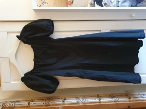 Fin svart klänning  - Väldigt fin svart klänning storlek 36 men upplever den mer som 34. Knappar framtill, fyrkantig halsringning och puffärmar. Aldrig använd pga att den var för liten för mig. Köparen står för frakten💕