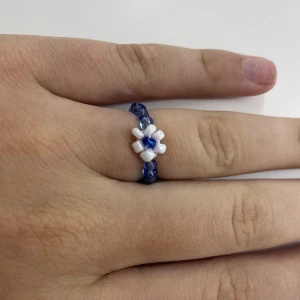 Blå ring - En blå pärlring med en vit blomma, den passar alla storlekar och om de finns frågor är de bara att kontakta oss💗💕