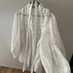 Superfin blus  - Säljer denna fina blus som är varsamt använd. Genomskinlig i fint skick. Tillhörande band till. Nypris 599