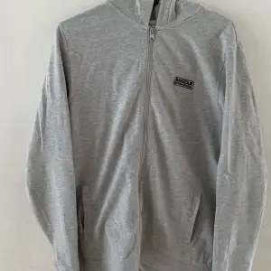 En grå zip hoodie från märket Barbour. Använd extremt lite så hoodien är i nyskick. Ny pris är 1200 kronor jag säljer den för 350 kronor. Tröjan är i storlek xs