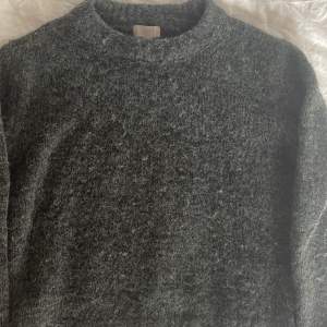 En mörk grå stickad tröja/ulltröja från H&M. Lite stor i armarna. Jag har använt den 2 gånger så skicket är bra