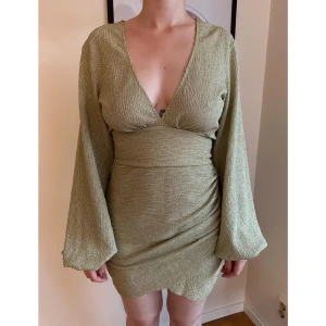 Guldig klänning - Guldig klänning med glittertråd från Nelly, storlek S. Använd 1 gång. Nypris 499 kr.