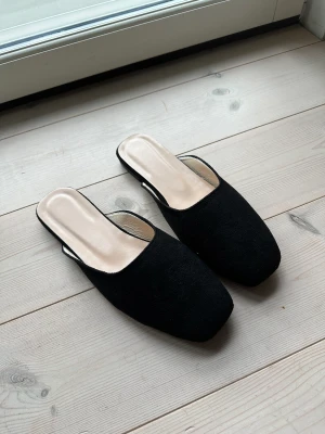 Helt nya svarta mules - Mjuka svarta slip-in mules, tofflor helt nya, säljes pga fel storlek. Har 39 men skulle säga att de passar 38. Sköna och mjuka