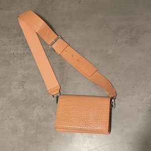 Carin Wester Crossbody Väska  - En så fin korallfärgad handväska från Carin Wester ✨ Säljer för jag använder inte den längre. Skriv för fler bilder!  Frakt ingår ej, kan mötas upp i Lund 